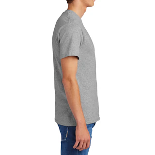 A man standing in profile and wearing a custom logo T shirt with medium wash denim.