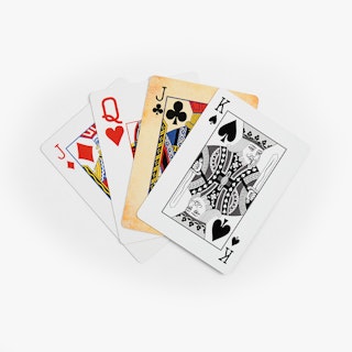 Four playing cards fanned out with different face styles on each one.