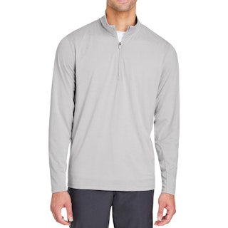 A man wearing a Puma pullover with a quarter zip and a white tee underneath.