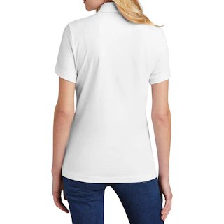 The back of a woman in a white business polo with dark denim.