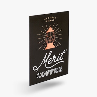 A custom printed aluminum sign with a black background, Merit Coffee in white and a lantern graphics.