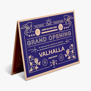 A custom announcement standing open and printed on Kraft paper with a blue design on the front.