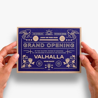 Two hands holding a custom announcement printed on Kraft paper with grand opening details on the front.