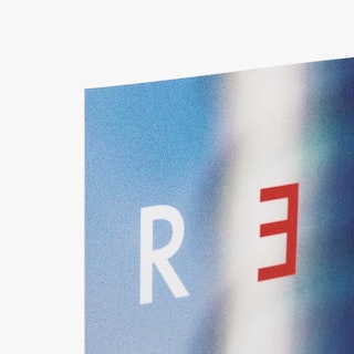 The top left corner of a backlit sign printed with a blue background and white and red letters.