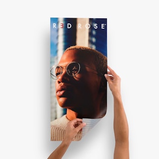 Two hands holding a backlit sign printed with a person wearing glasses and rolling back one corner.