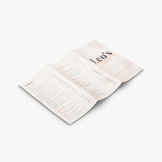 A custom menu laying unfolded with three panels and printed with Leo's Table and lunch items.