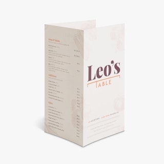 A brochure menu standing open with three panels and printed with Leo's Table in maroon and orange on the front.