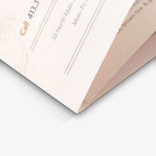 The bottom corner of a brochure menu with three folded panels and printed with orange and black text.