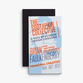 Two business card magnets overlapping each other and printed with The Southpaw Collective in orange.