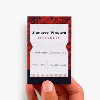 A hand holding a custom business card printed with Jomaree Pinkard Cofounder on a red and black background.