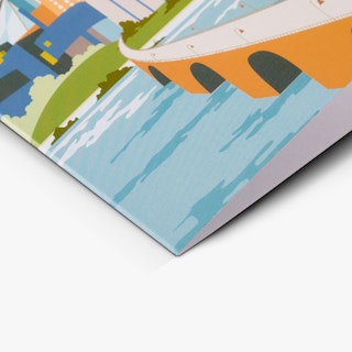 The corner of a custom card printed with a blue, green and orange design of a bridge over water.