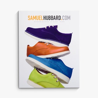 A cardstock sign custom printed with a stack of four shoes in different colors.