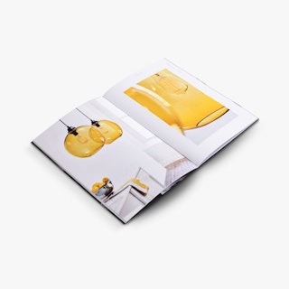 A product catalog laying open to images of light fixtures with golden yellow glass.