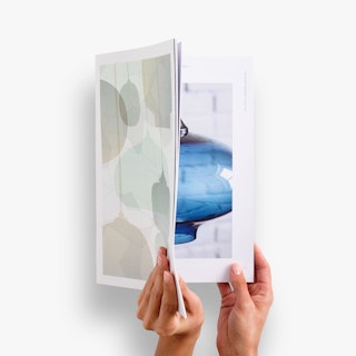 Two hands holding open a custom catalog printed with images of light fixtures.