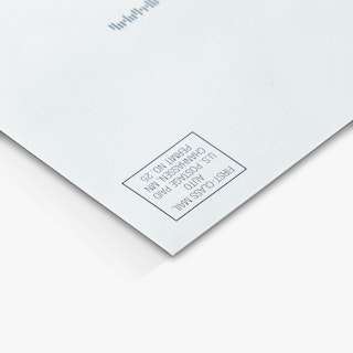 The top right corner of a direct mail envelope printed with first-class postage indicia.