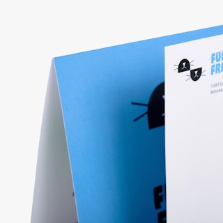 The top left corners of a direct mail card and envelope printed with a blue and black design.