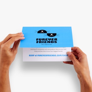 Two hands opening a direct mail card printed with Furever Friends Pet Rescue in black and blue.