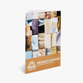 A direct mail catalog standing and printed with Pacha Soap Co Product Catalog in white and caramel tan.