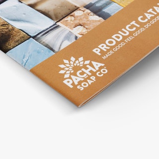 The bottom left corner of a custom catalog printed with a saddle stitch binding and bars of soap on the cover.