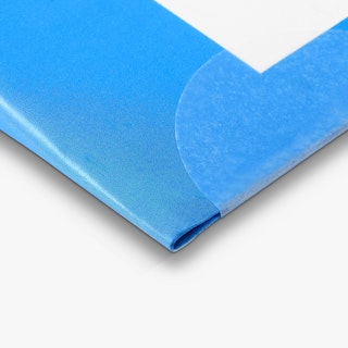 The corner of a direct mail newsletter printed with a blue and white design and a wafer seal.