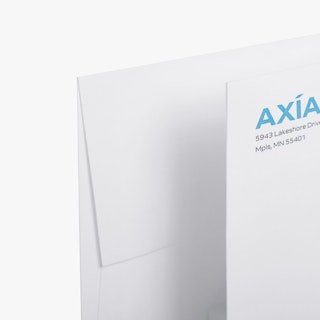 The top left corners of two custom envelopes printed with the AXIA name and address.