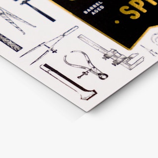 The bottom corner of a custom business card printed with graphics of tools and gold foil accents.