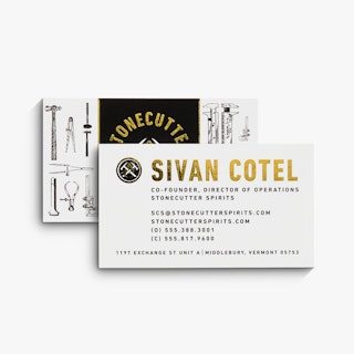 Two gold foil business cards printed with Stonecutter Spirits, tool graphics and gold foil accents.