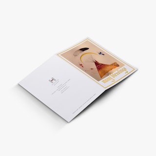 A foil greeting card laying flat and printed with gold foil words and accents, plus indigenous artwork.
