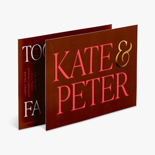 Two foil wedding invites overlapping each other and printed with a maroon background and a gold foil accent.