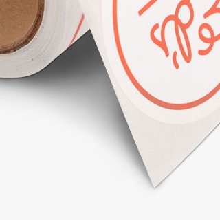 Custom food labels on a roll and printed with a white and red design.