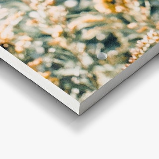 The bottom corner of a custom sign printed with an abstract design in shades of green, orange and white.