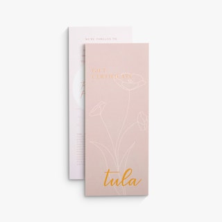 Two gift certificates overlapping each other and printed with Tula in orange and a floral design in white.