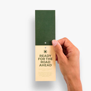 A hand holding a hang tag printed with Ready for the Read in green.