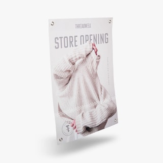 A custom hanging banner printed with Store Opening and a person putting on a sweater.