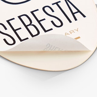 A health and beauty label peeling off its backing and printed with Sebesta Apothecary in black and tan.