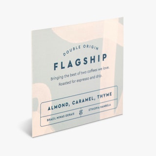 A square label printed with Double Origin Flagship and coffee bean details below it.