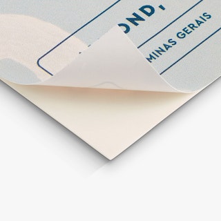 The bottom corner of a custom product label peeling off its backing.