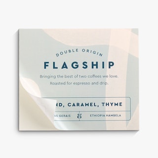 A coffee bean bag label printed with a square shape and Double Origin Flagship in the middle.