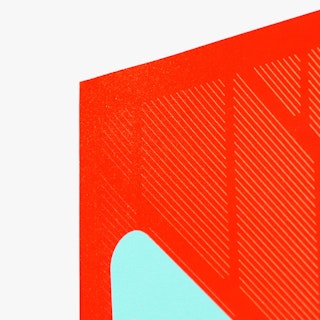 The corner of a large poster custom printed with a bright red and light blue design.