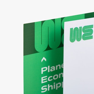 The top left corners of a letter mail and matching envelope printed with WE and a green and white design.