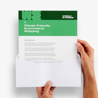 Two hands holding a letter mailer printed with a green and white design coming out of an envelope.