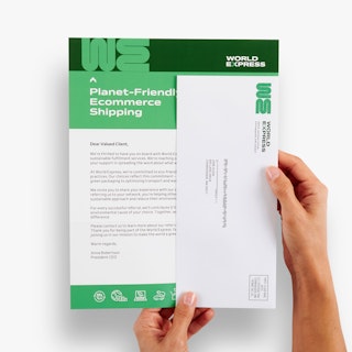 Two hands holding a custom letter mailer printed with World Express details and a matching envelope.