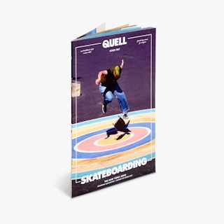 A custom magazine printed with Quell in white text and a person skateboarding on a rainbow bullseye.