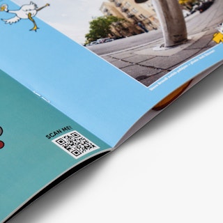 A magazine with a saddle stitch binding laying open to pages printed with teal and blue background.