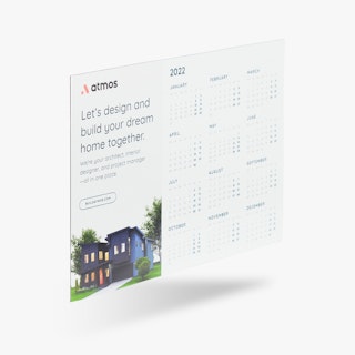 A magnet calendar printed with Atmos at the top and an image of a black house next to the months of the year.