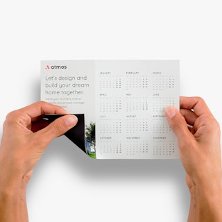 Two hands holding a magnetic calendar and bending up the bottom corner.