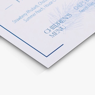 The bottom corner of a menu card printed with menu items in dark blue text on a white background.