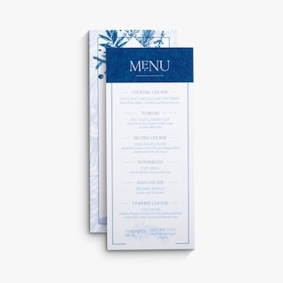 Two menu cards overlapping each other and printed with a blue and white foliage design and course details.
