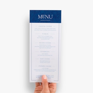 A hand holding a custom menu card printed with a blue and white design and seven menu items.