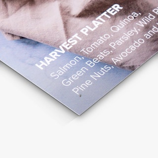 The bottom corner of a custom menu insert printed with Harvest Platter and ingredients in white text.